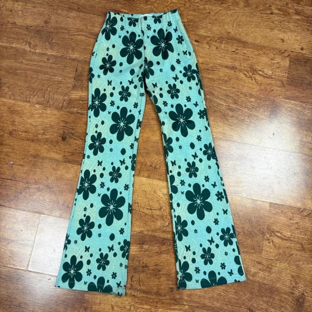 Urban Outfitters green floral flare pants, distressed leg openings and pilling